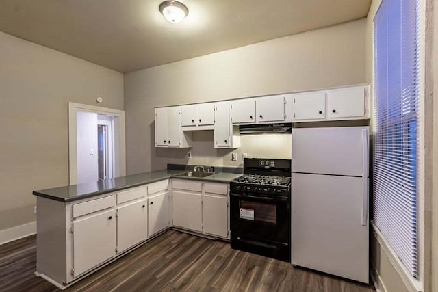 kitchen with gas stove, kitchen peninsula, white cabinetry, and white refrigerator