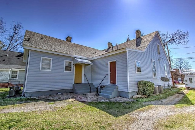 view of front of home with central air condition unit and a front yard