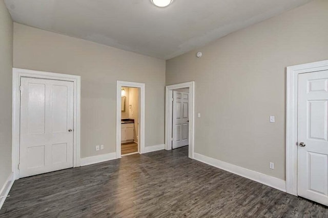 unfurnished bedroom with dark hardwood / wood-style flooring and ensuite bathroom