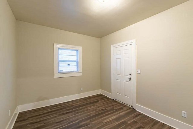 empty room with dark hardwood / wood-style flooring