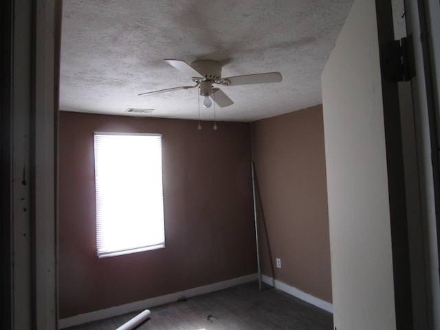 spare room featuring hardwood / wood-style floors, ceiling fan, and a textured ceiling