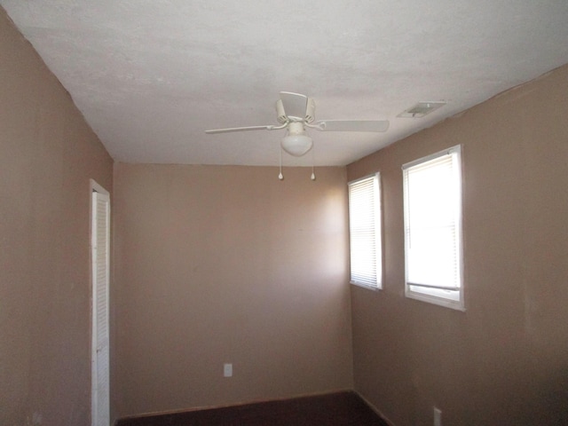 unfurnished room with ceiling fan and a textured ceiling