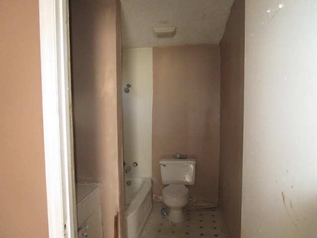 bathroom featuring a tub to relax in and toilet