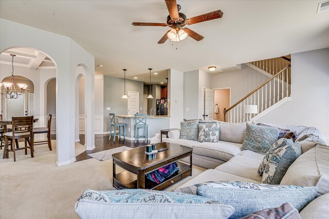 3374 Grove Landing Cir, Grovetown, GA 30813 - carpeted living area with arched walkways, a ceiling fan, a chandelier, stairs, and wainscoting