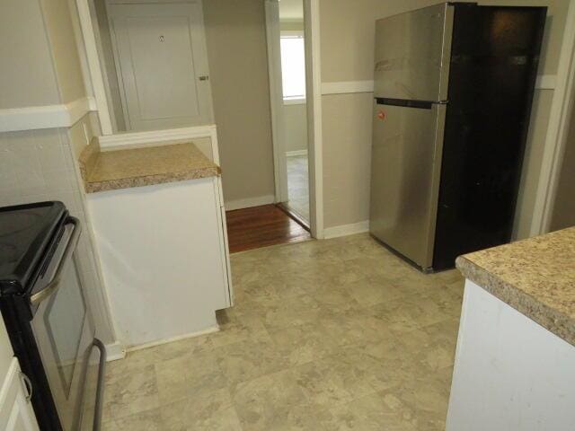 2810 Anne St, Augusta, GA 30906 - kitchen featuring freestanding refrigerator, electric stove, white cabinetry, and light countertops