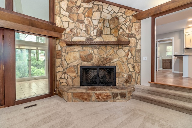 705 Woodgate Ct, Augusta, GA 30909 - unfurnished living room featuring carpet, a stone fireplace, and healthy amount of natural light