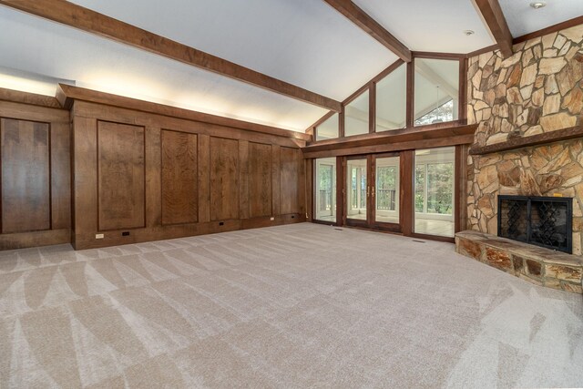 705 Woodgate Ct, Augusta, GA 30909 - unfurnished living room with beam ceiling, light colored carpet, a fireplace, wood walls, and high vaulted ceiling