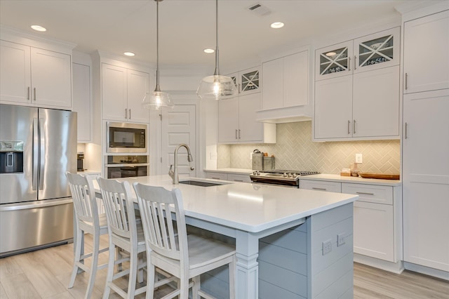 508 Oakley Grv Cir, Evans, GA 30809 - kitchen featuring stainless steel appliances, a breakfast bar area, a kitchen island with sink, light countertops, and light wood-style flooring