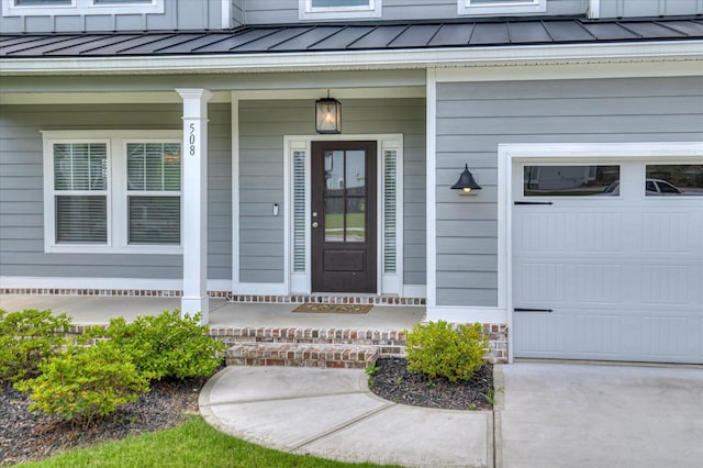 508 Oakley Grv Cir, Evans, GA 30809 - view of exterior entry featuring a standing seam roof, covered porch, a metal roof, and a garage