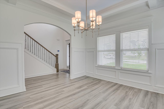 508 Oakley Grv Cir, Evans, GA 30809 - unfurnished dining area featuring a decorative wall, arched walkways, light wood-style flooring, a chandelier, and stairs