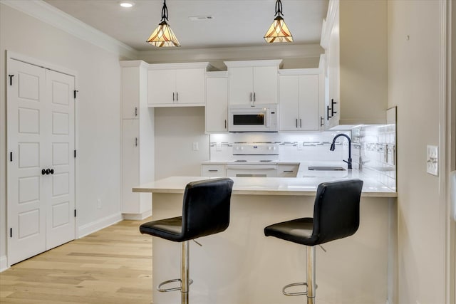 6135 Mottled Duck Dr, North Augusta, SC 29860 - kitchen featuring white appliances, a sink, tasteful backsplash, white cabinetry, and pendant lighting