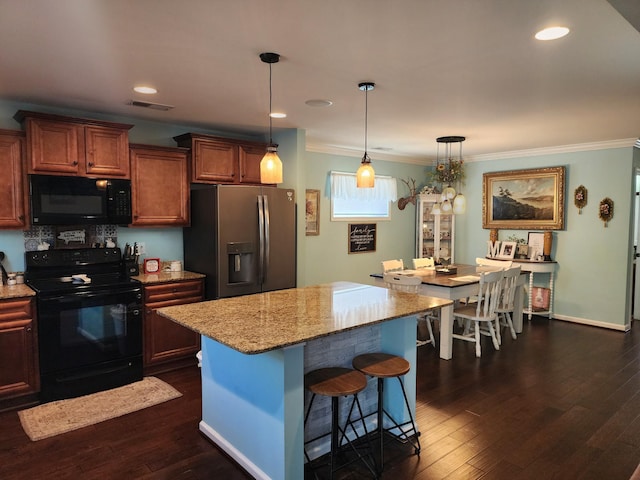 kitchen featuring black appliances, a breakfast bar area, dark wood-style floors, and crown molding