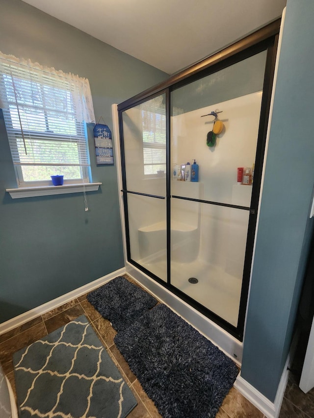 full bathroom featuring tile patterned floors, baseboards, and a stall shower