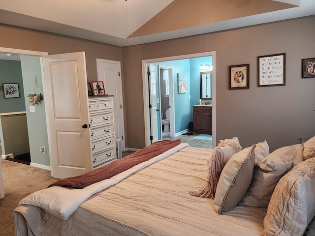 bedroom with ensuite bath, vaulted ceiling, baseboards, and carpet floors