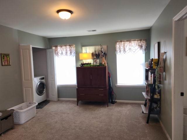 living area featuring visible vents, washer / dryer, carpet flooring, and a healthy amount of sunlight