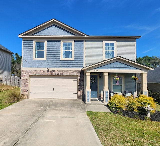 view of front of property featuring driveway, stone siding, a porch, fence, and an attached garage