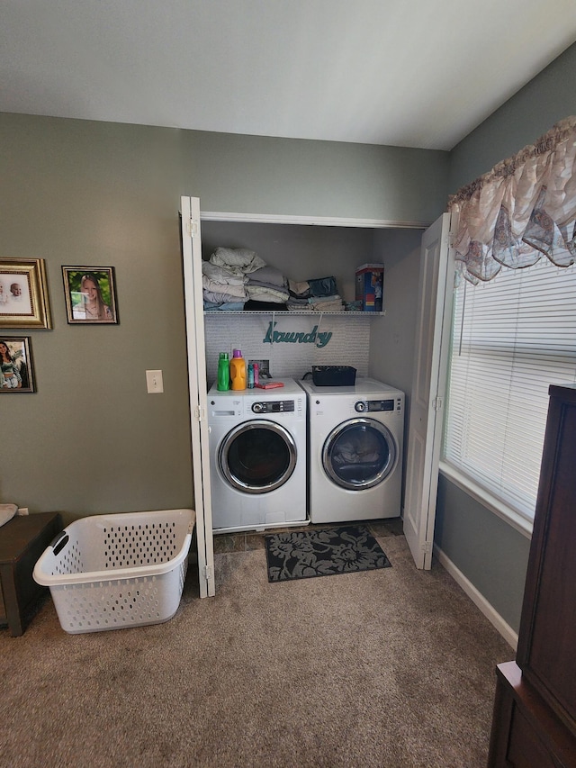 washroom featuring washing machine and clothes dryer, laundry area, baseboards, and carpet