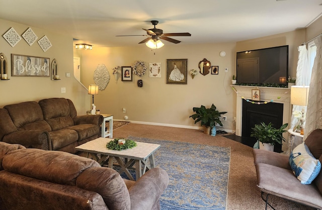 carpeted living area featuring a fireplace with flush hearth, baseboards, and ceiling fan