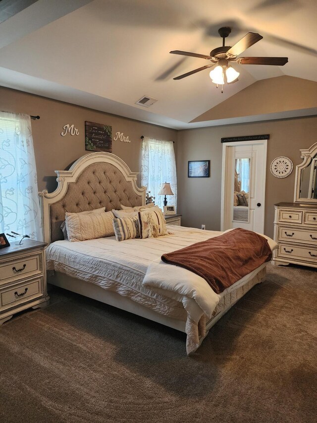 bedroom featuring vaulted ceiling, visible vents, dark colored carpet, and ceiling fan