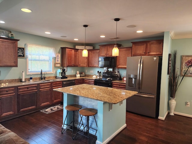 kitchen with a sink, black appliances, dark wood-style floors, and a breakfast bar