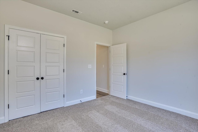 unfurnished bedroom featuring carpet flooring and a closet