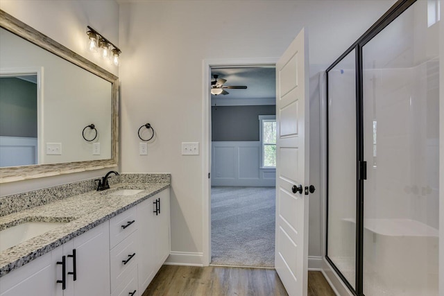 bathroom featuring vanity, ceiling fan, crown molding, hardwood / wood-style floors, and a shower with shower door