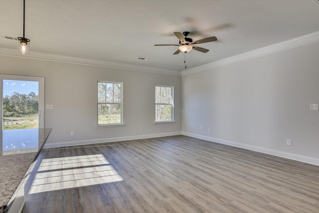 spare room featuring wood-type flooring, ceiling fan, and crown molding