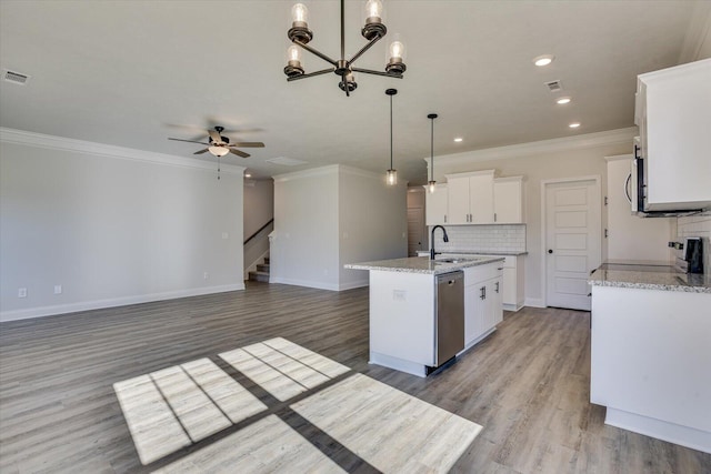 kitchen featuring white cabinetry, tasteful backsplash, decorative light fixtures, a center island with sink, and range