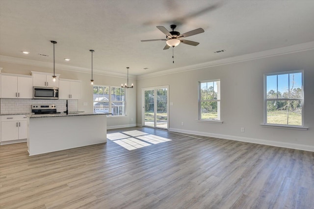 kitchen featuring hanging light fixtures, stainless steel appliances, a center island with sink, white cabinets, and ceiling fan with notable chandelier