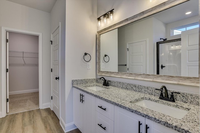 bathroom featuring hardwood / wood-style floors, vanity, and a shower with shower door