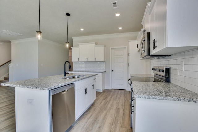 kitchen featuring pendant lighting, light stone countertops, an island with sink, appliances with stainless steel finishes, and white cabinetry