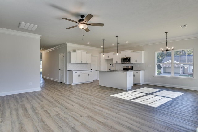 kitchen featuring appliances with stainless steel finishes, sink, white cabinetry, and an island with sink