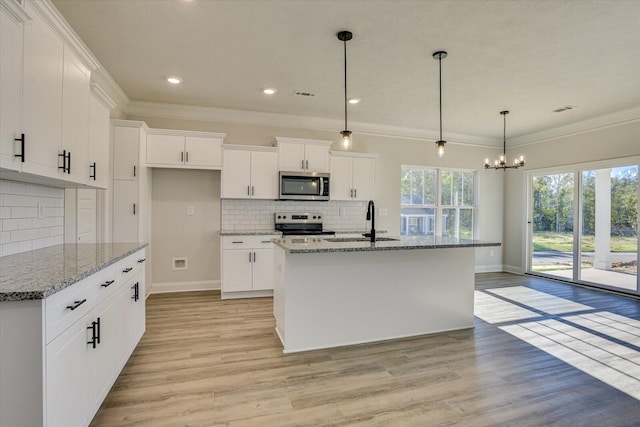 kitchen featuring pendant lighting, white cabinets, light stone countertops, an island with sink, and appliances with stainless steel finishes