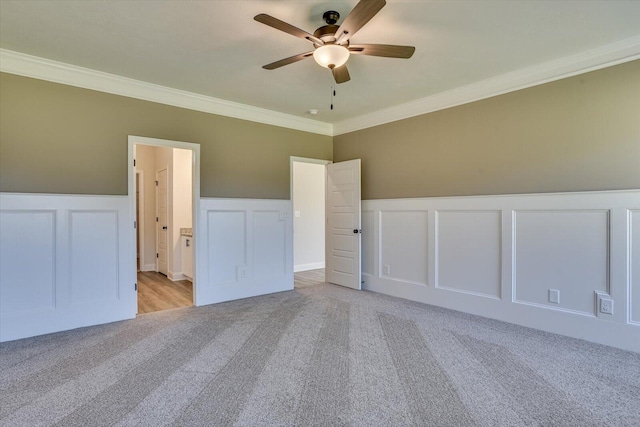 spare room with light colored carpet, ceiling fan, and crown molding