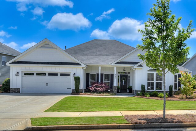 385 Bridle Path Rd, North Augusta, SC 29860 - view of front facade with board and batten siding, a front lawn, a garage, driveway, and a shingled roof