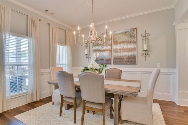 385 Bridle Path Rd, North Augusta, SC 29860 - dining space featuring a chandelier, a decorative wall, wood finished floors, wainscoting, and crown molding