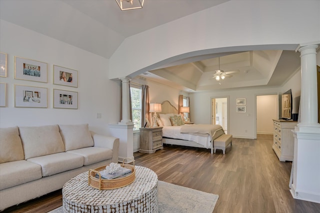 385 Bridle Path Rd, North Augusta, SC 29860 - bedroom featuring decorative columns, a tray ceiling, wood finished floors, arched walkways, and lofted ceiling