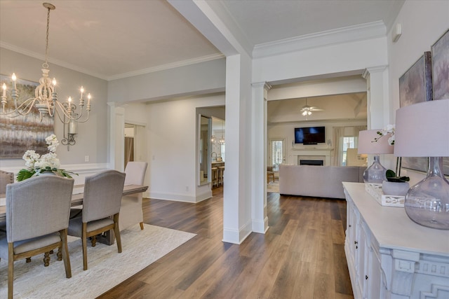 385 Bridle Path Rd, North Augusta, SC 29860 - dining room featuring a fireplace, a ceiling fan, crown molding, a chandelier, and dark wood-style floors