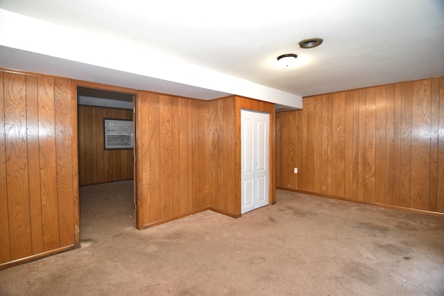 finished basement with baseboards, carpet floors, and wooden walls