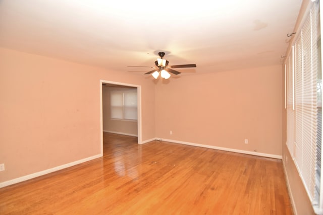 unfurnished room with a ceiling fan, baseboards, and light wood finished floors