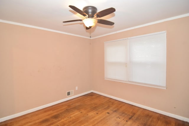 unfurnished room with baseboards, crown molding, and wood finished floors