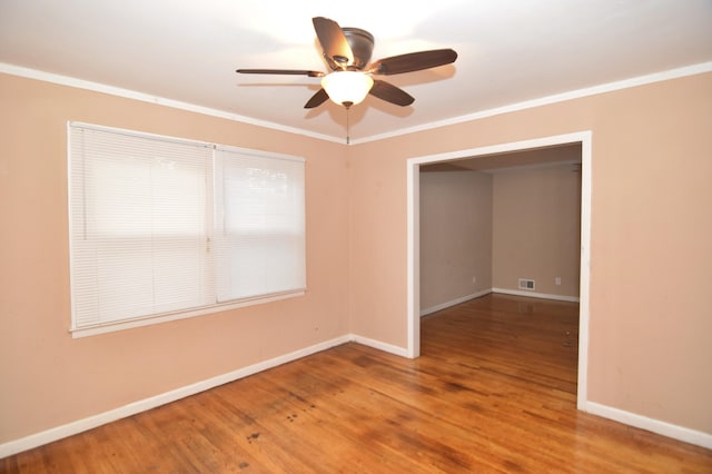 unfurnished room featuring visible vents, baseboards, wood finished floors, and ornamental molding