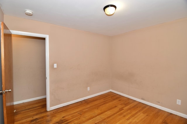 empty room featuring wood finished floors and baseboards