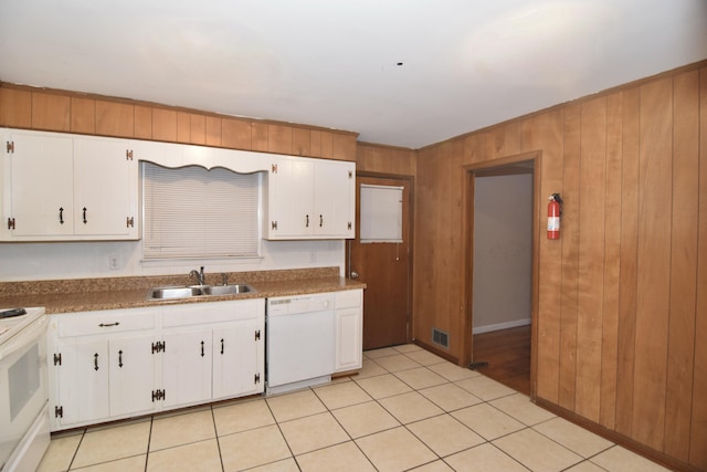 kitchen with white appliances, visible vents, wood walls, white cabinetry, and a sink