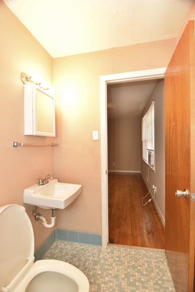 bathroom with toilet, baseboards, and a sink