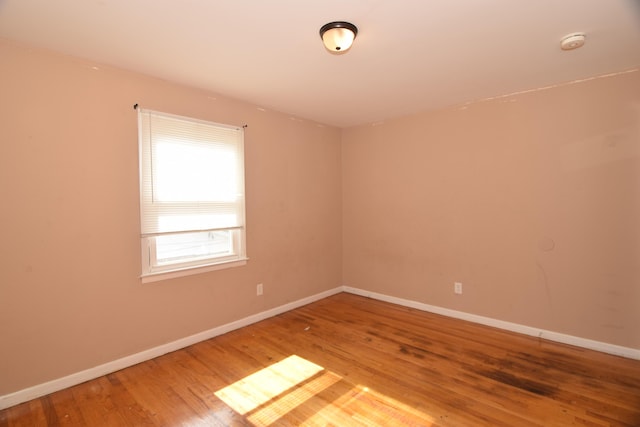 empty room featuring wood finished floors and baseboards