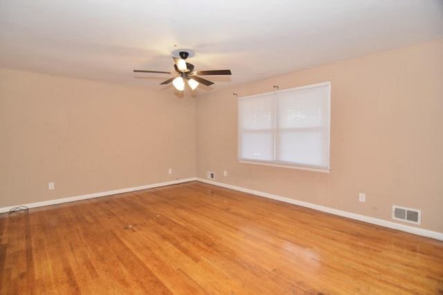 unfurnished room featuring visible vents, ceiling fan, baseboards, and wood finished floors