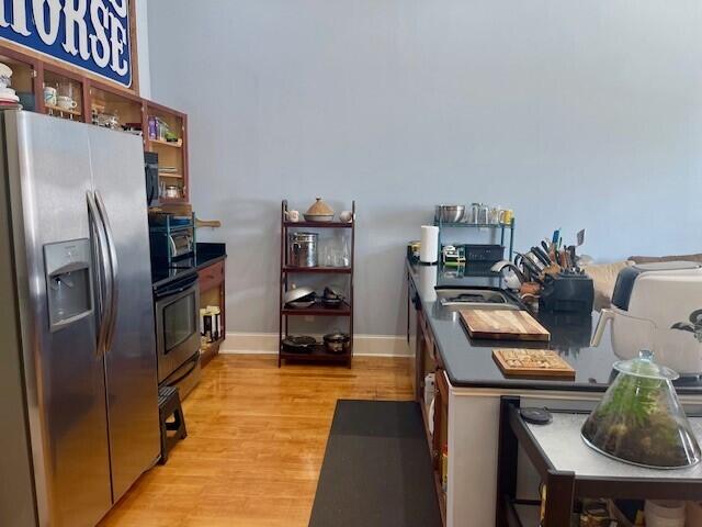 kitchen featuring light hardwood / wood-style floors, stainless steel fridge with ice dispenser, sink, and range