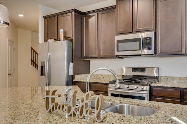 kitchen featuring light stone countertops, dark brown cabinets, and appliances with stainless steel finishes