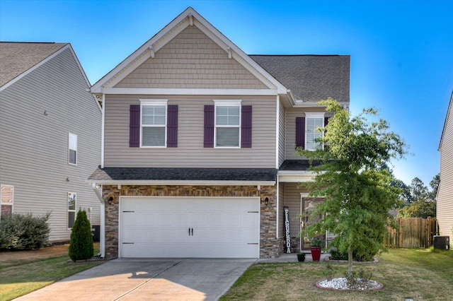 craftsman-style house featuring central air condition unit, a front yard, and a garage